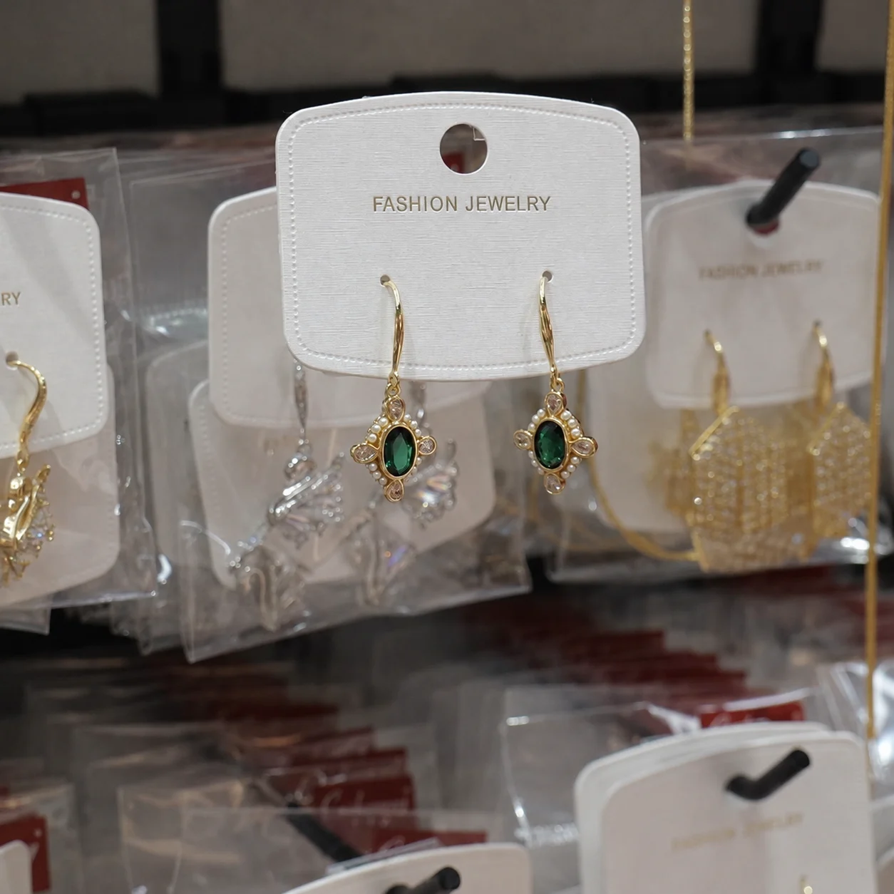 Gold-tone Drop Earrings with Deep Green Oval Centers and Clear Accents